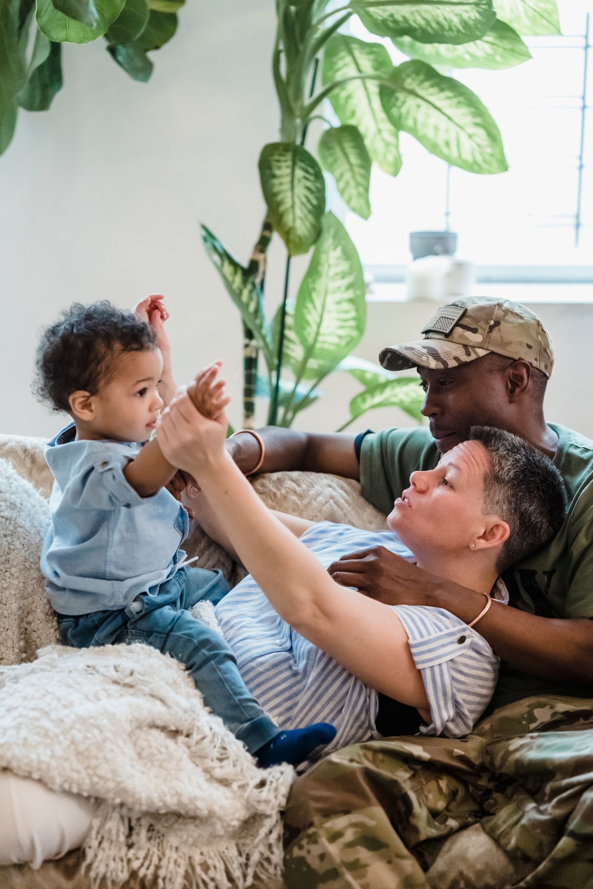 A military family relaxing together at home with their child